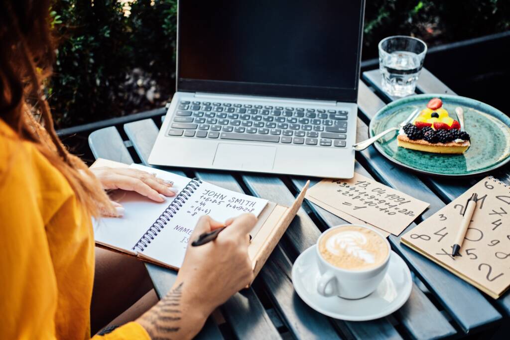 Woman numerologist working with numbers in notepad and laptop. Numerology Numbers
